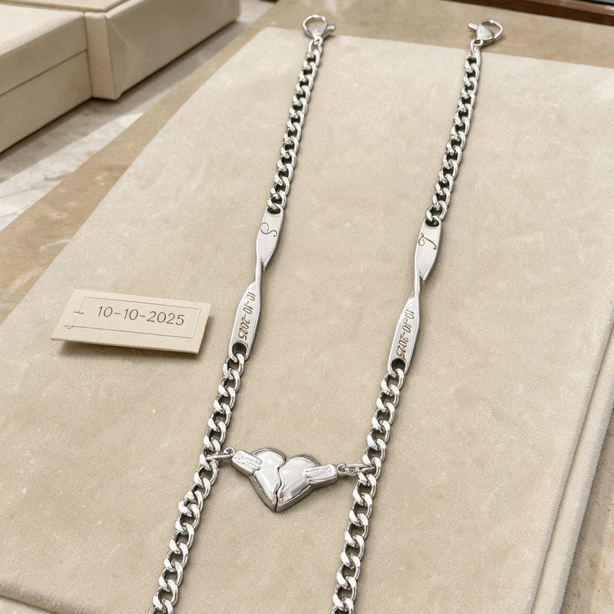 Bracciali Sempre Insieme color argento con iniziali e data, esposti con i due mezzi cuori uniti.