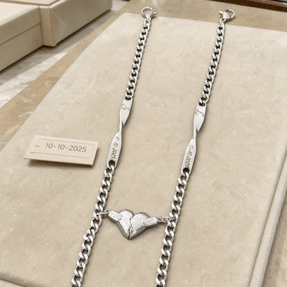 Bracciali Sempre Insieme color argento con iniziali e data, esposti con i due mezzi cuori uniti.